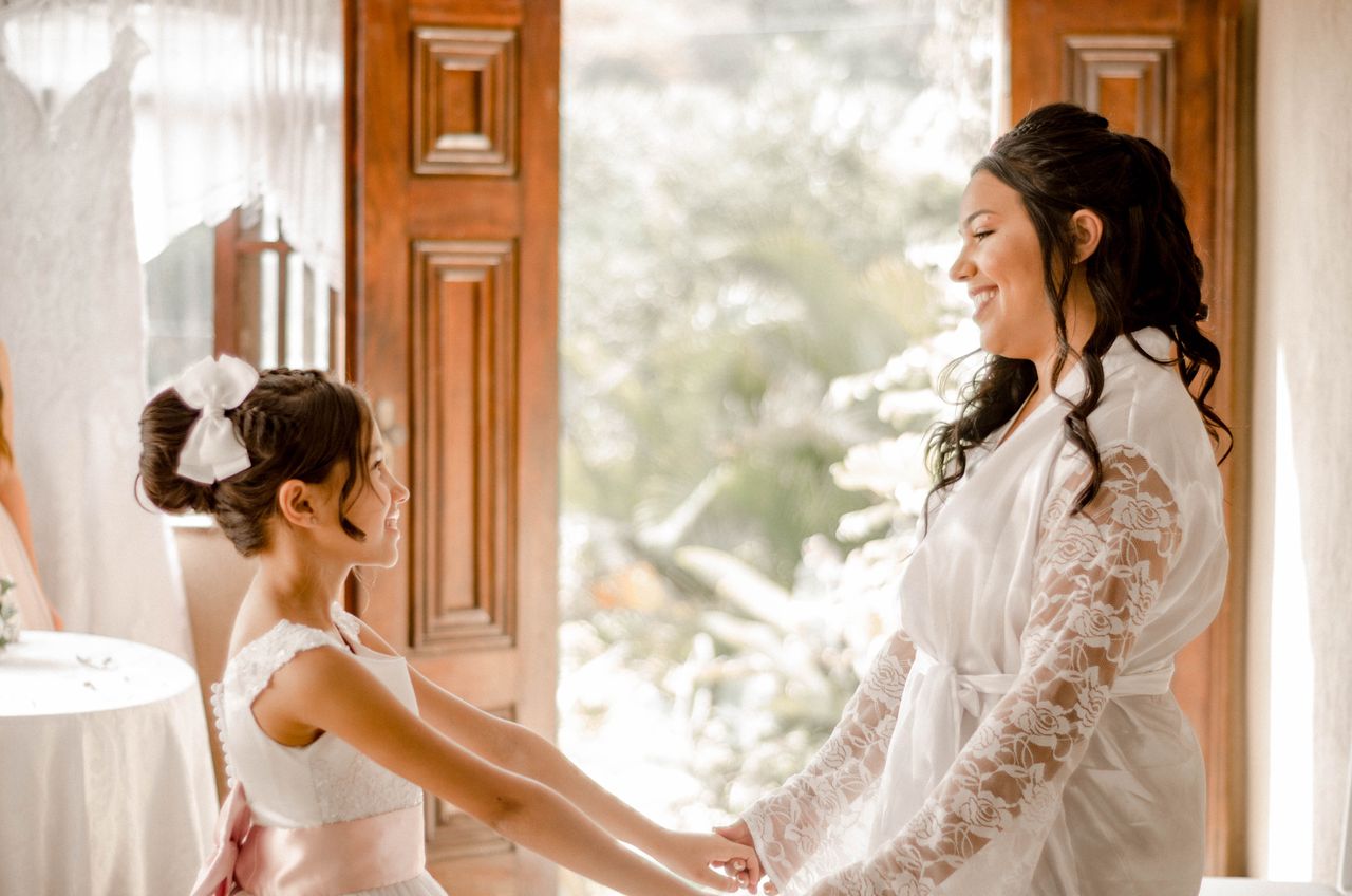 Joyful mother and daughter holding hands, sharing a tender moment before a wedding.